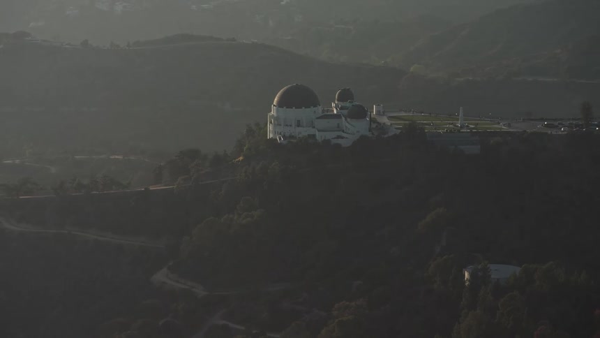 A domed building on top of a hill surrounded by trees