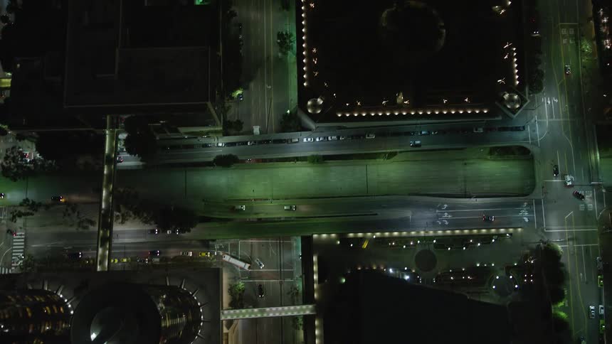 Aerial view of a metropolis at night with streets and intersections with vehicle traffic and skyscrapers