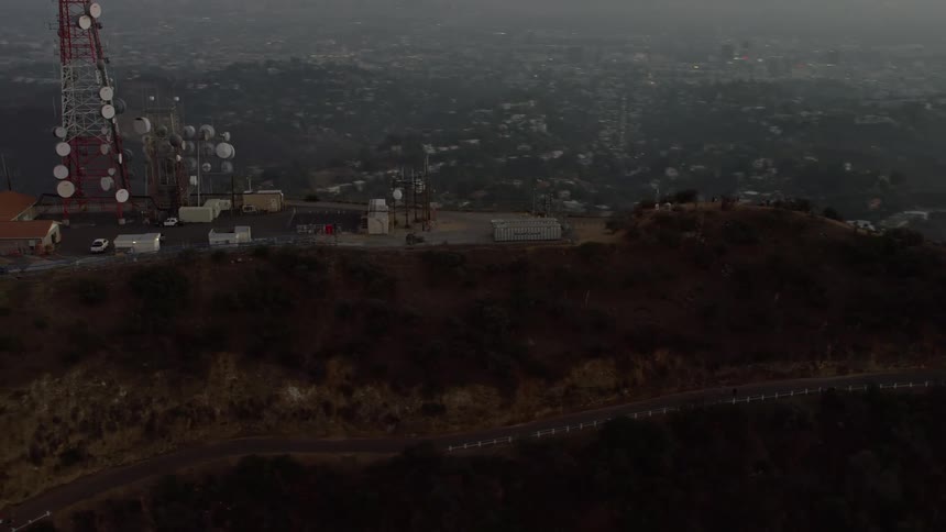 Aerial view of an antenna array over the hollywod sign in los angeles at sunset