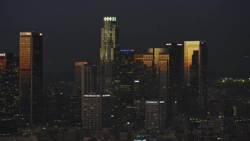 Lights glow on towers and skyscrapers overlooking the metropolitan city