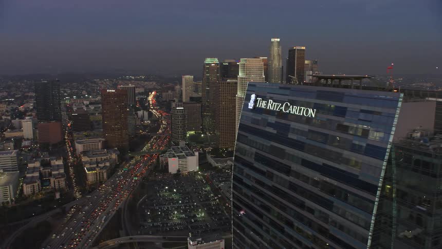 Aerial panorama of skyscrapers in a metropolis with an illuminated stadium at dusk