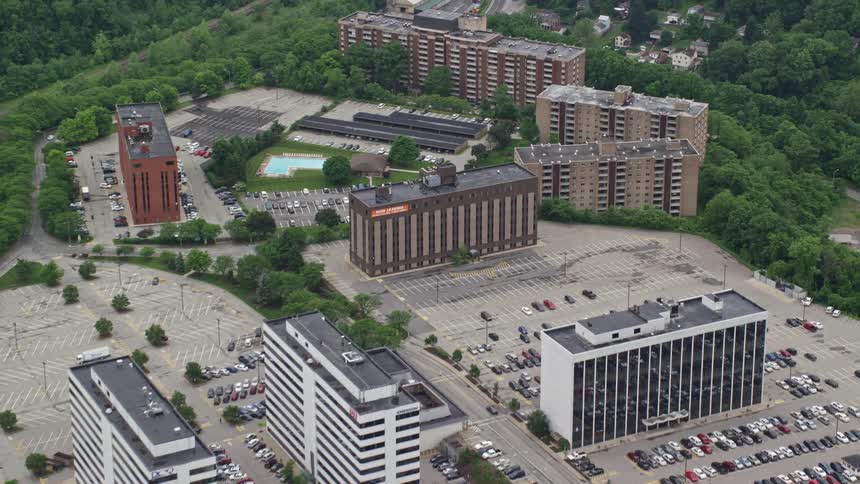 Aerial view of a campus with multiple buildings surrounded by greenery