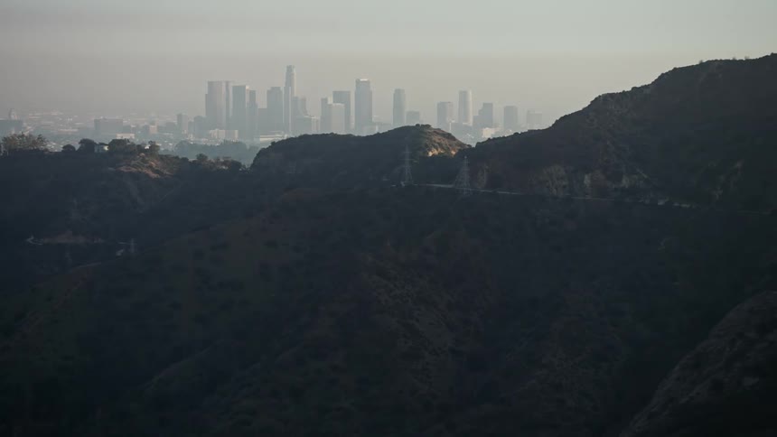 A shot of the hollywood hills with the los angeles city skyline in the background