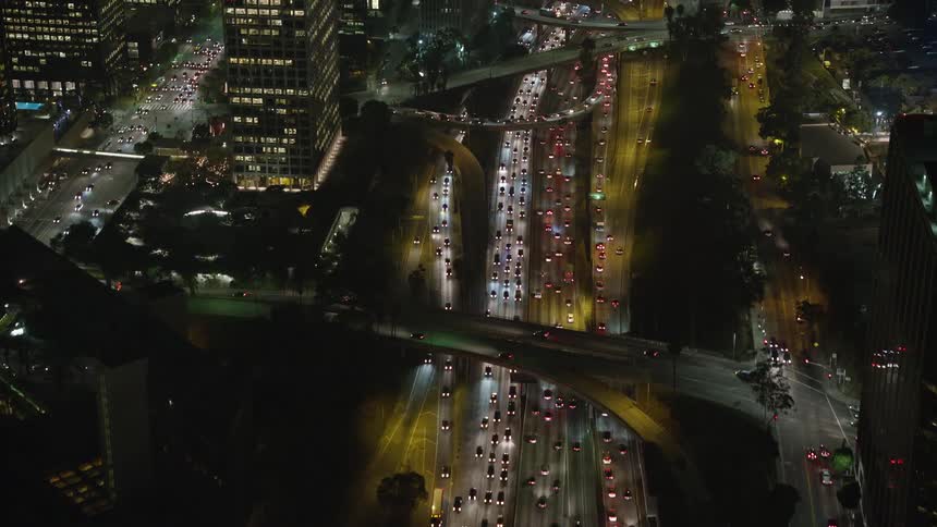 Night aerial panorama of highways in a metropolis with large buildings