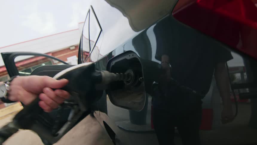 Person putting the valve to fuel his vehicle at a gas station