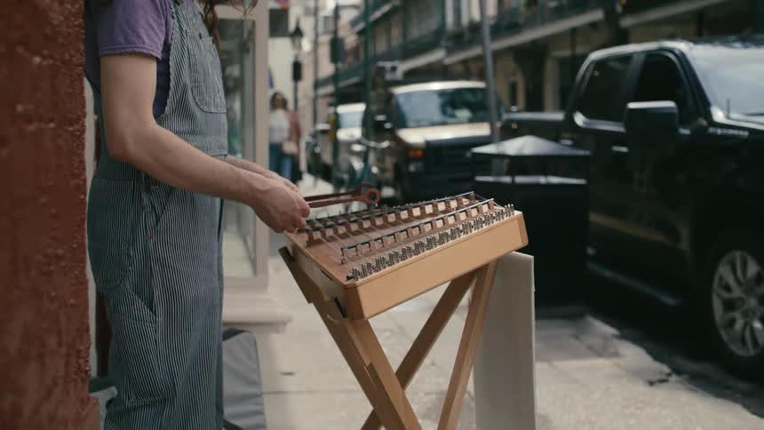 A person is playing an instrument on the sidewalk