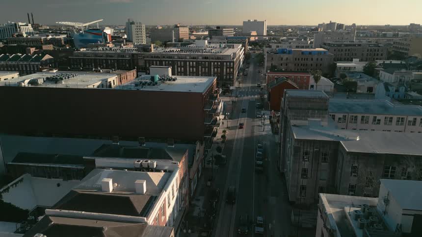 An aerial view of a city avenue with houses and lowrise buildings