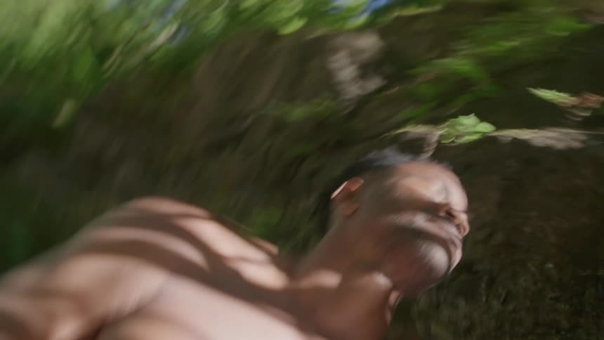 Smiling man without a shirt in nature and with sunlight on his face