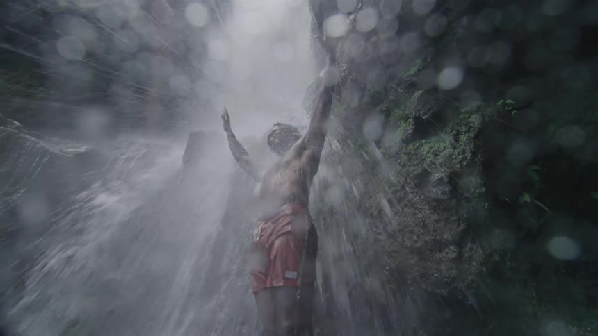 A person bathing under the waterfall