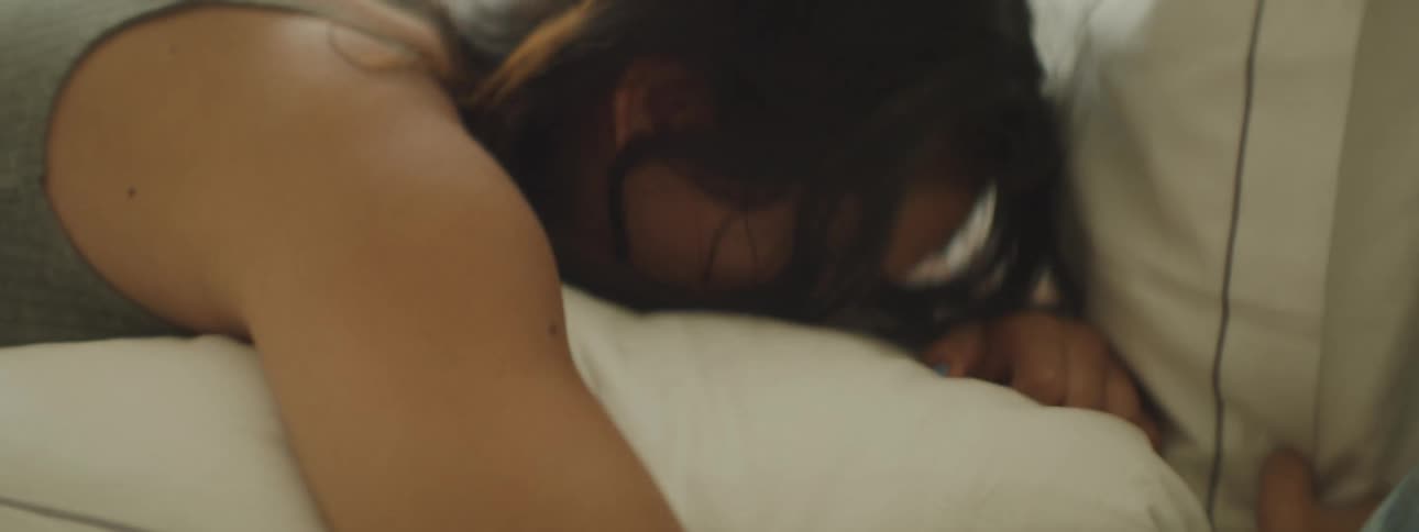 Close up of a girl waking up in bed looking at the camera
