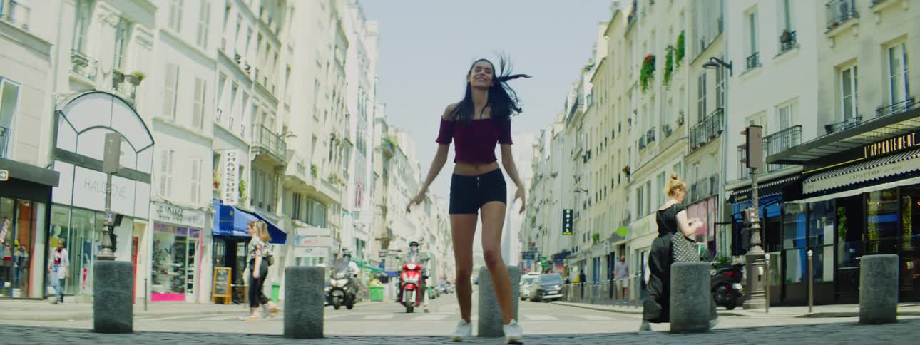 A young woman jumps with happiness in the street