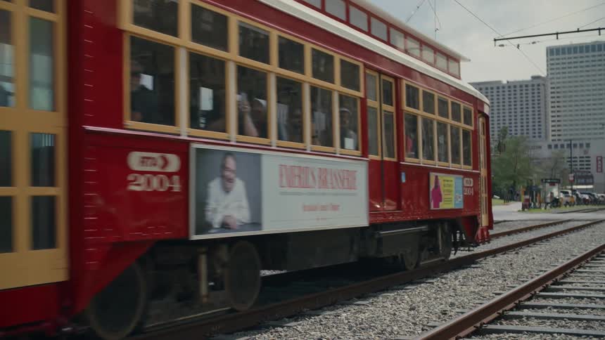 Cable car passing along a train track in the middle of the city