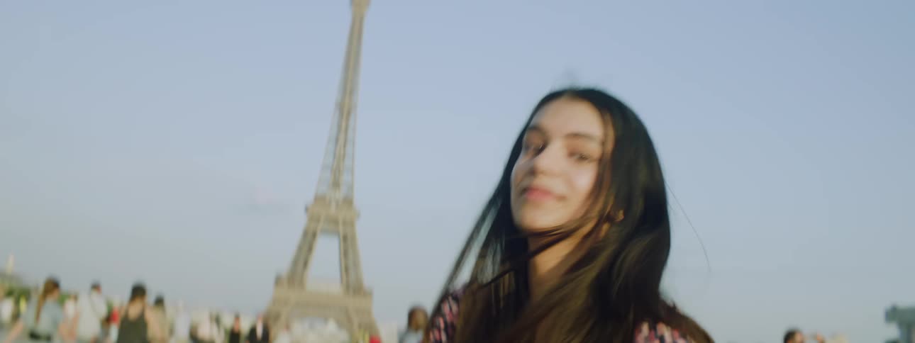 Young woman in selfie smiling while standing in a square with the eiffel tower in france