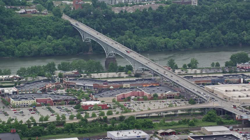 A bridge spans a river as numerous vehicles pass over it
