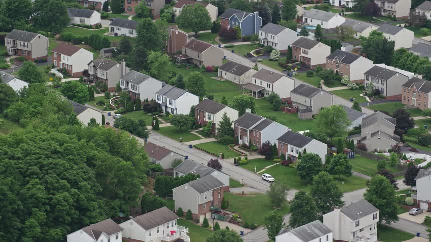 Aerial panorama of a residential neighborhood built on hills with vegetation