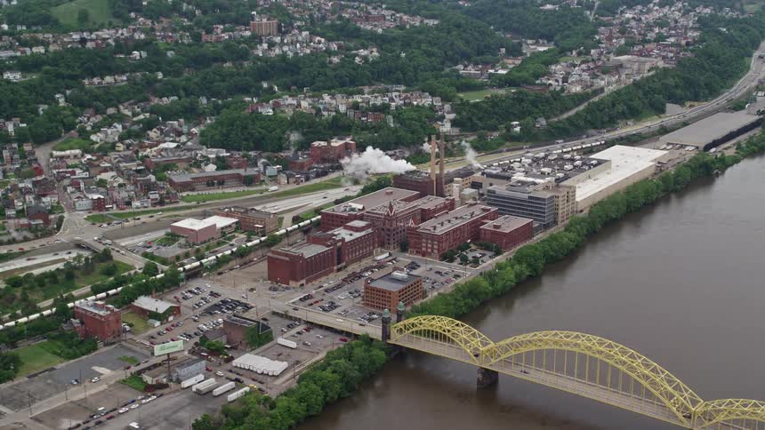 Aerial panorama of a city with urban neighborhoods factories and buildings on the banks of a river canal