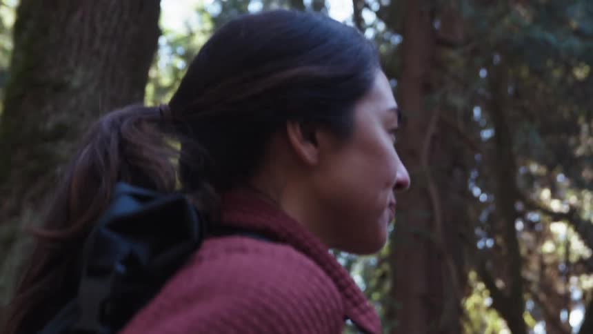 A woman is hiking in the woods