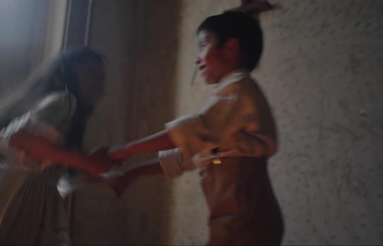 Two kids dance in a room