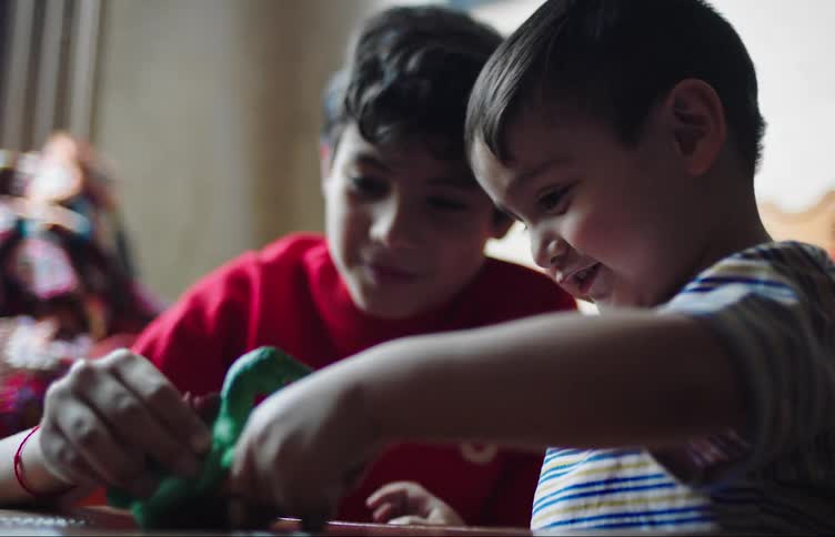 Two little boys are playing with rubber toys and are happy