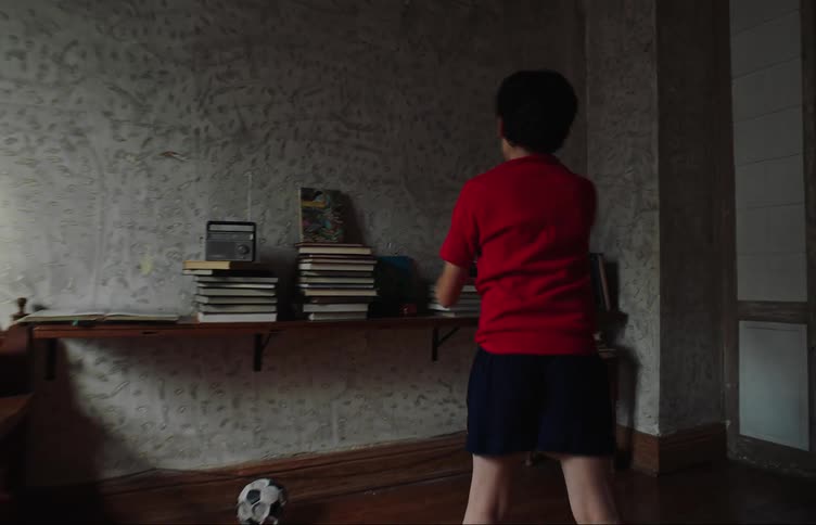 A boy bouncing a ball on his bedroom walls