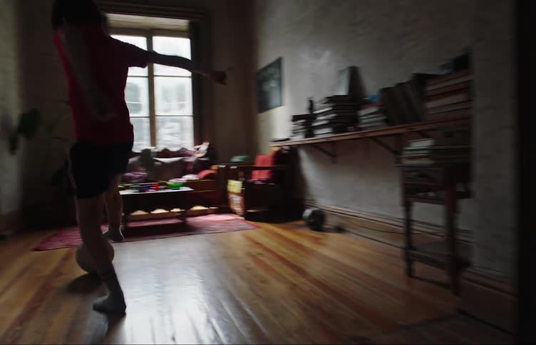 A clip of a boy playing football in the room