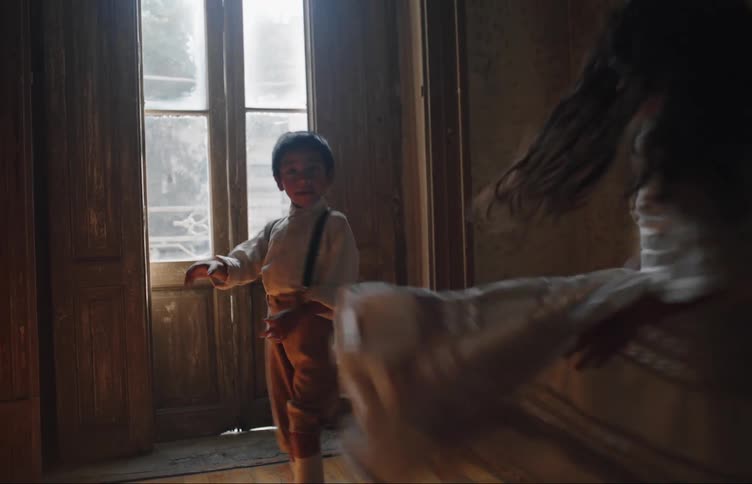 Two children dance by the window