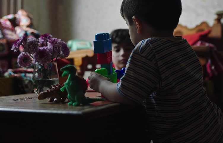 Two boys play with building blocks