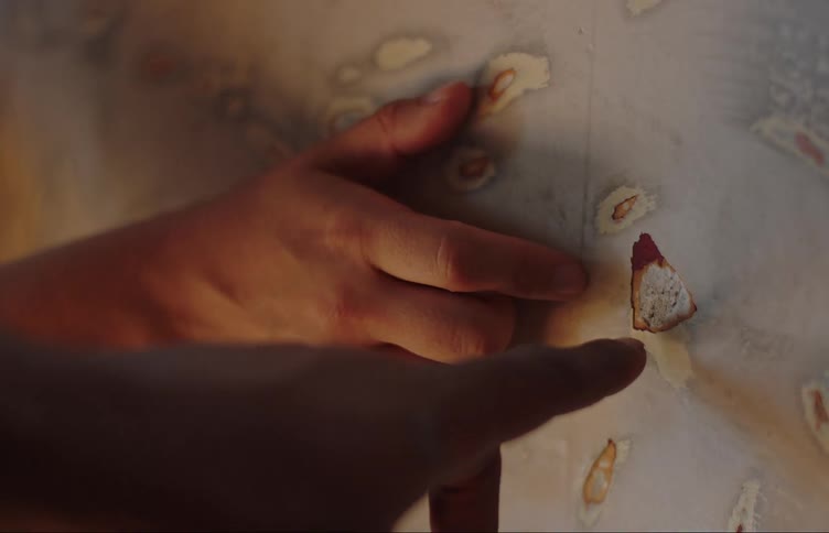 Hands of two people analyzing a small hole in a wall