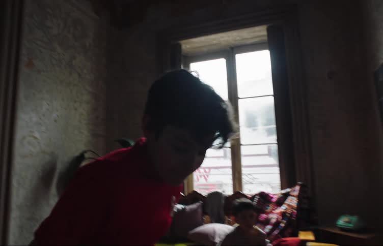 Two children play soccer in the house