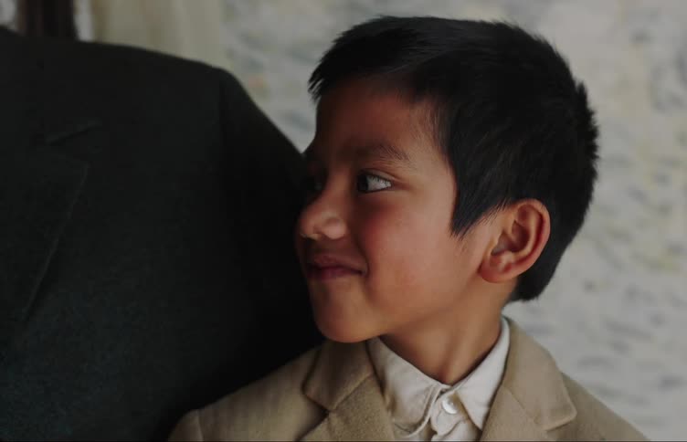 Portrait of a little boy in a suit landing next to his father