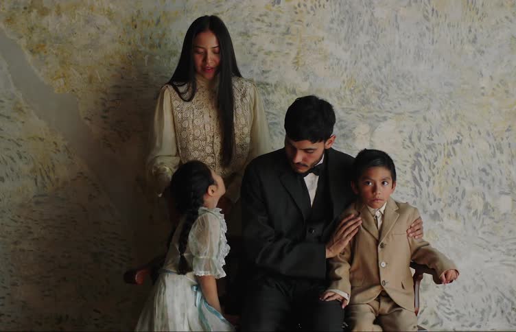 A middle eastern family with two young children poses indoors for a portrait