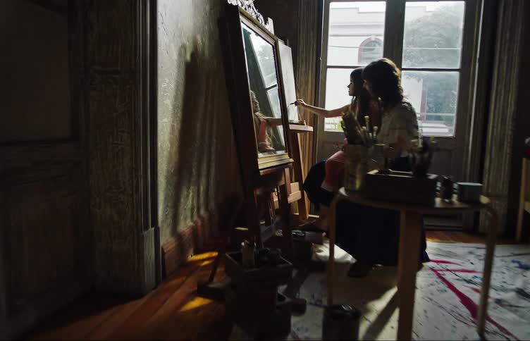 A woman helps her daughter draw