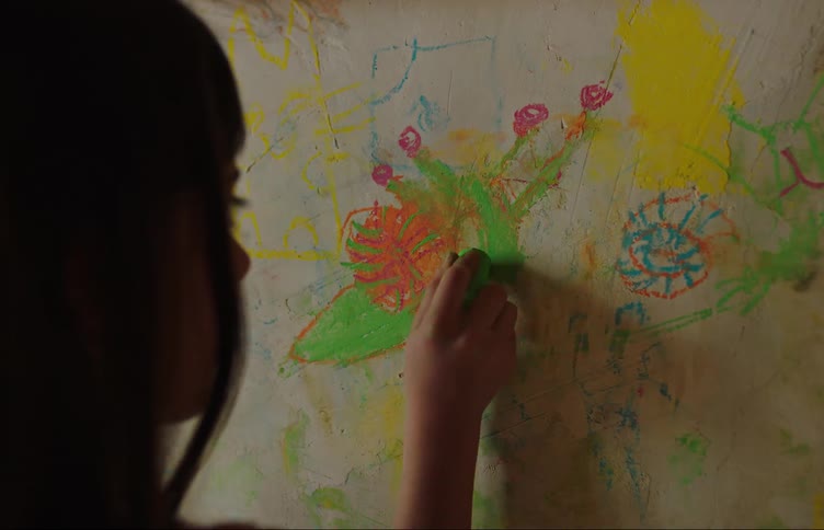 Girl with long hair draws on the wall in color