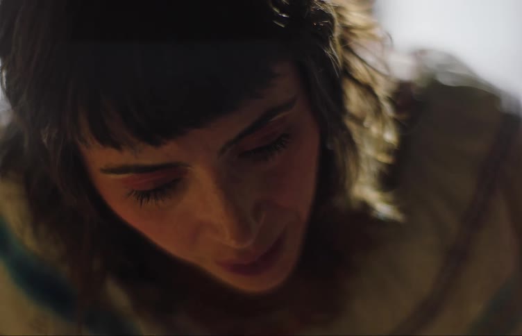 A woman is looking down and talking