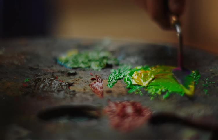 A person mixes paint on a palette