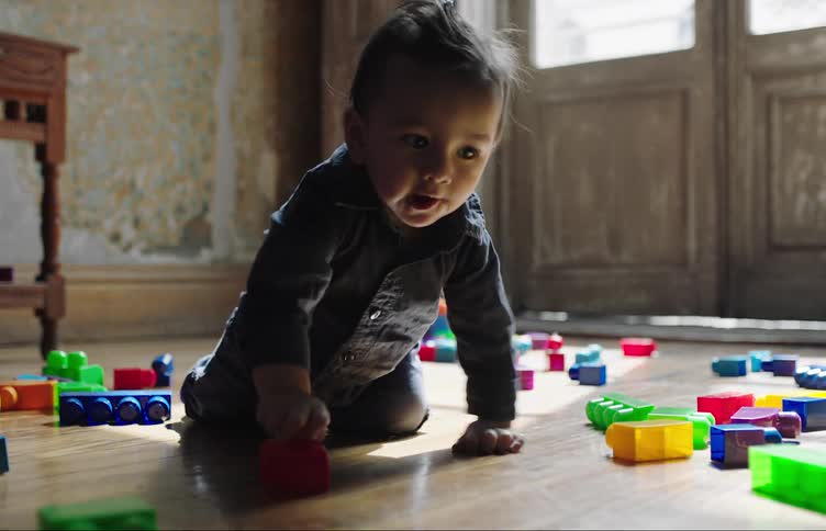 Toddler playing with plastic blocks at home