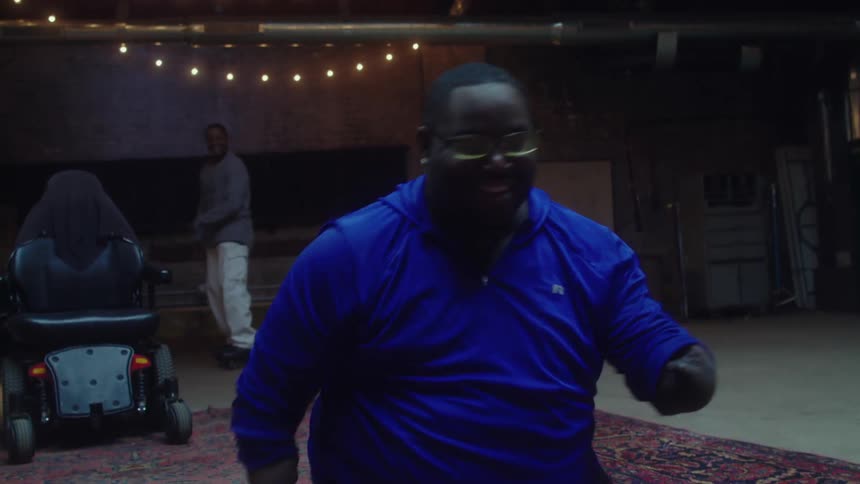 A disabled man happily dancing in a spacious room