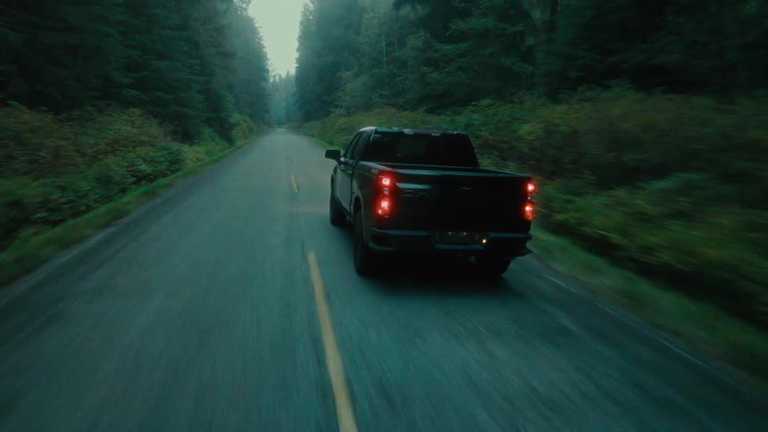 A truck drives down the forest road