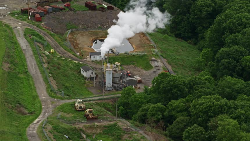 A refinery blows plumes of smoke into the air
