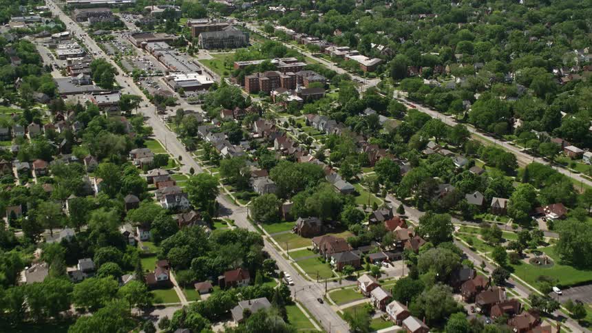 Cars drive through streets in a large suburb