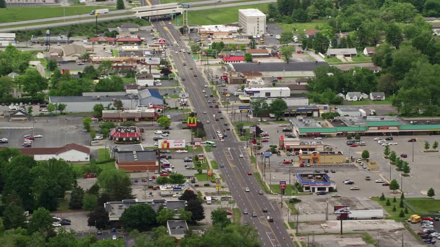 Aerial panorama of a city with a central highway and shops around it