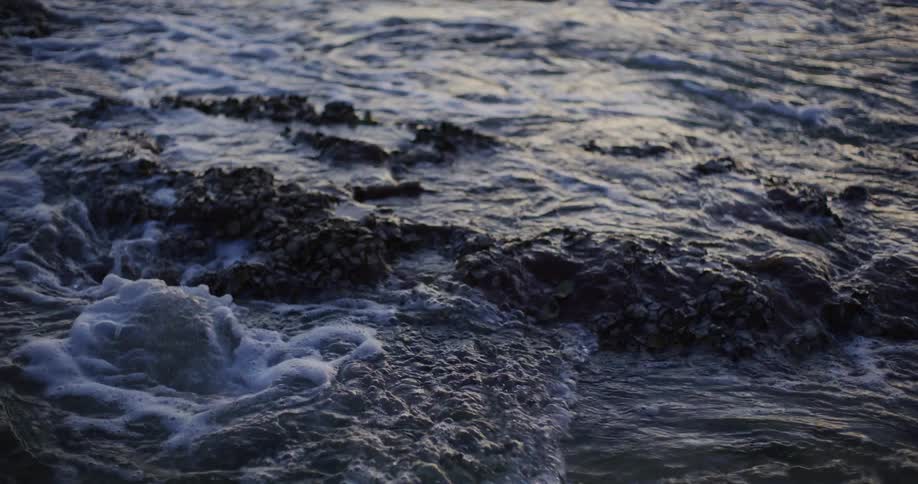 Rock in the middle of the sea with water and the morning solar reflection