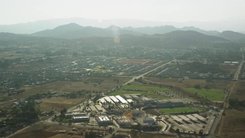 Aerial panorama and an urban city surrounded by mountains around on a morning with solar reflection