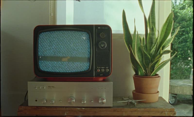 Vintage television sitting on a wooden table at midday