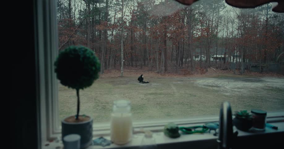 A person sitting outside seen through a kitchen window