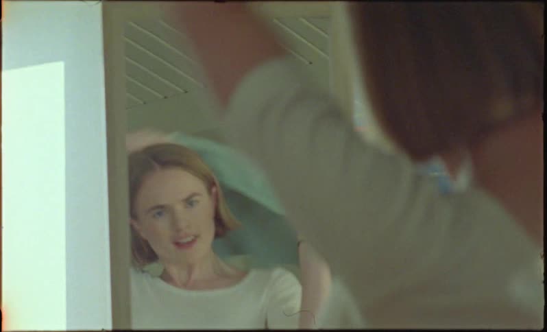 Woman trying on clothes in front of a mirror