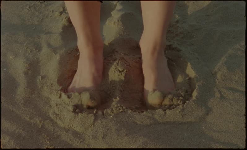 A person is digging their feet in the sand