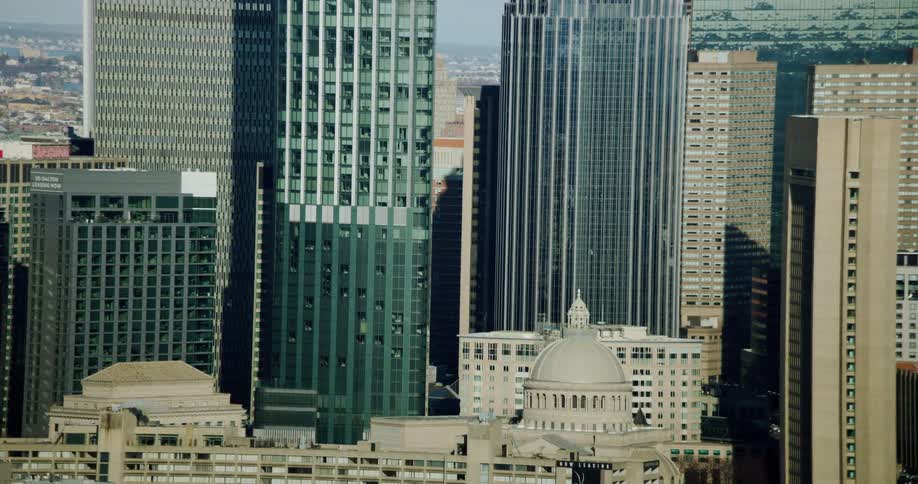 Downtown skyscrapers tower over domed building and nearby mid rise buildings