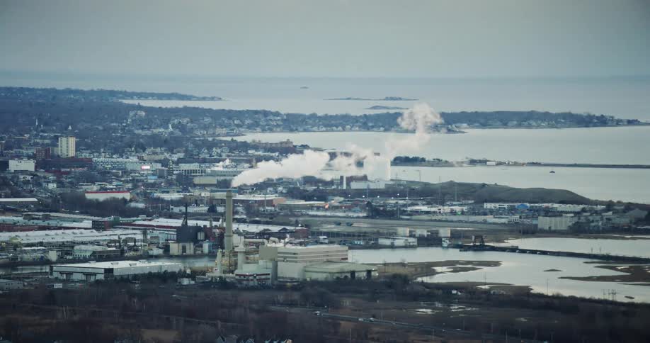 Aerial view of a factory or power plant near a coastal town