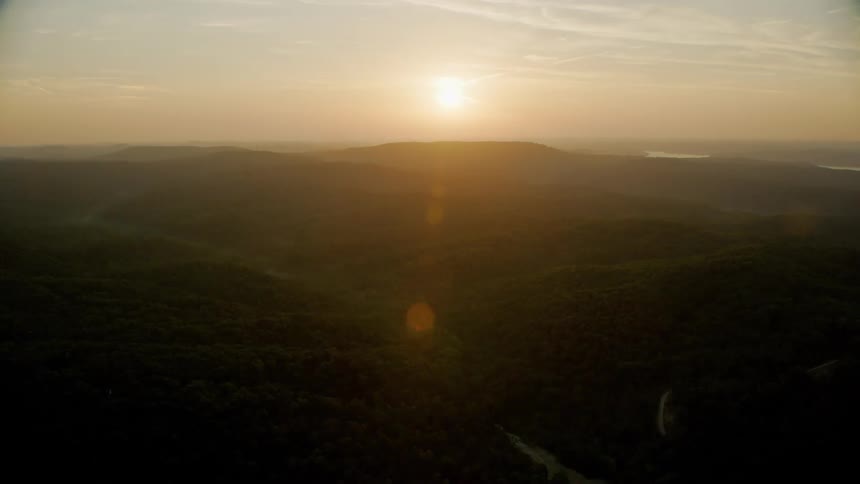 Aerial view of a serene landscape with winding rivers and hills at dusk